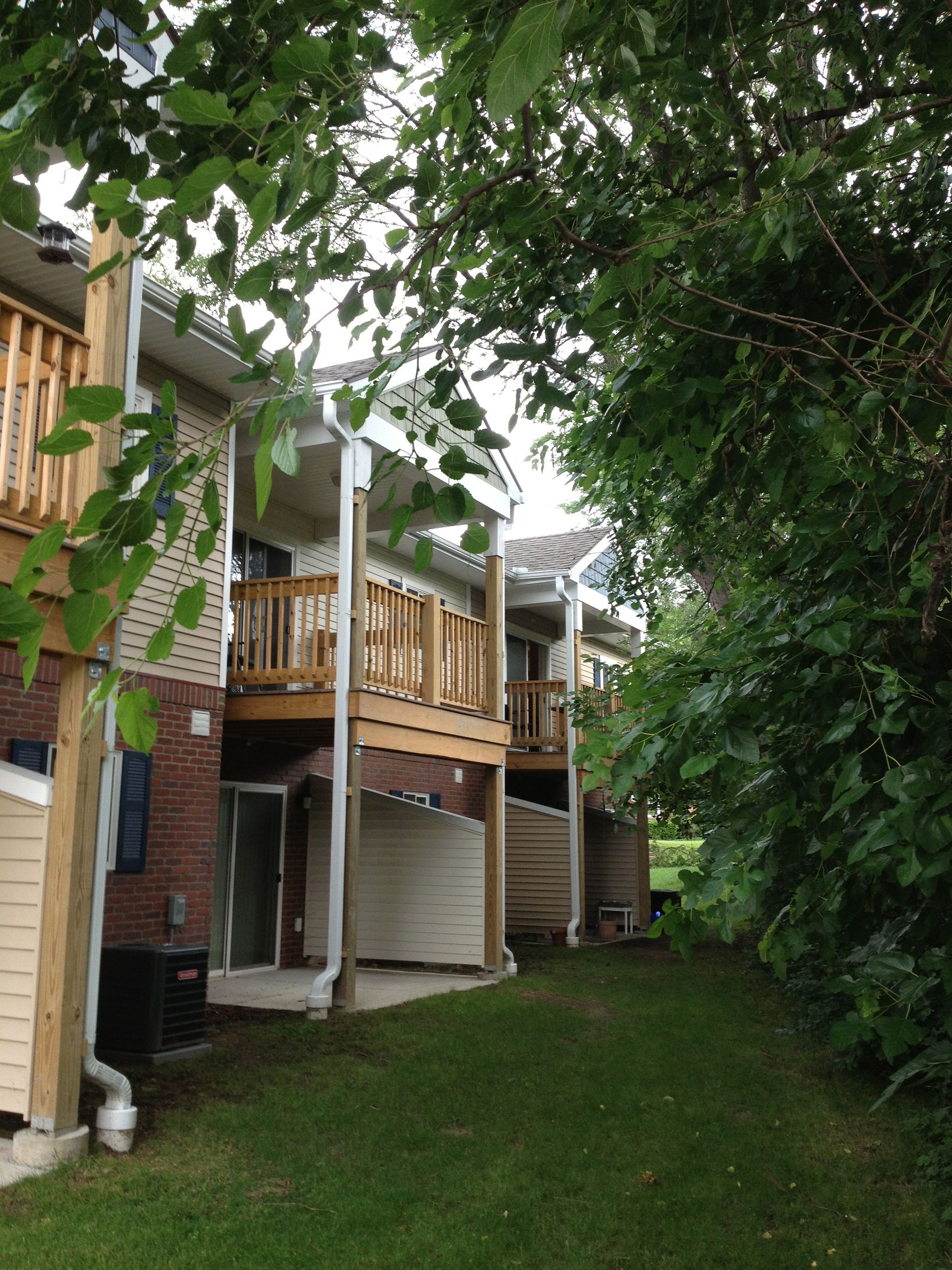 A row of houses with balconies and trees in front of them