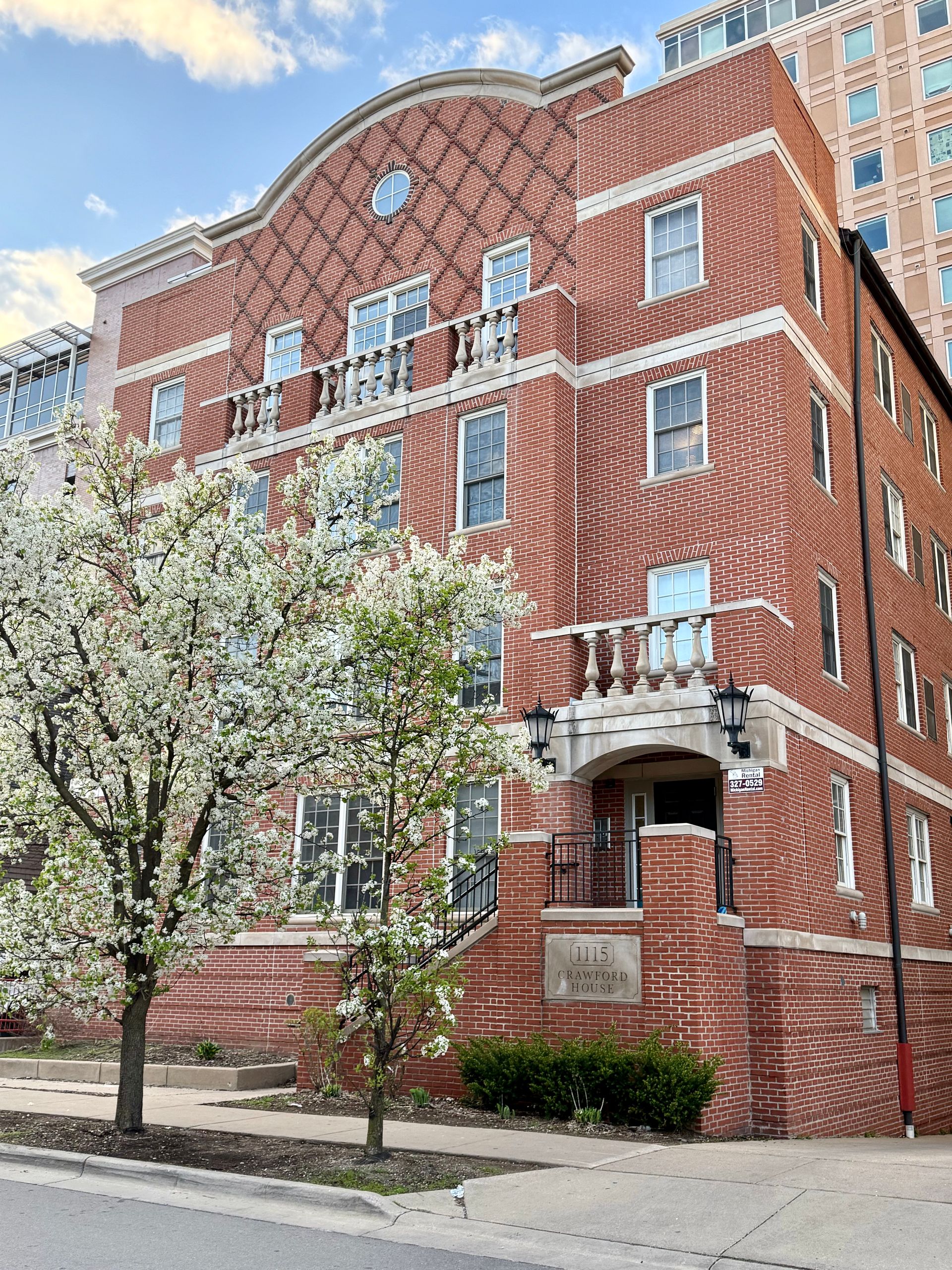 A large brick building with a tree in front of it.