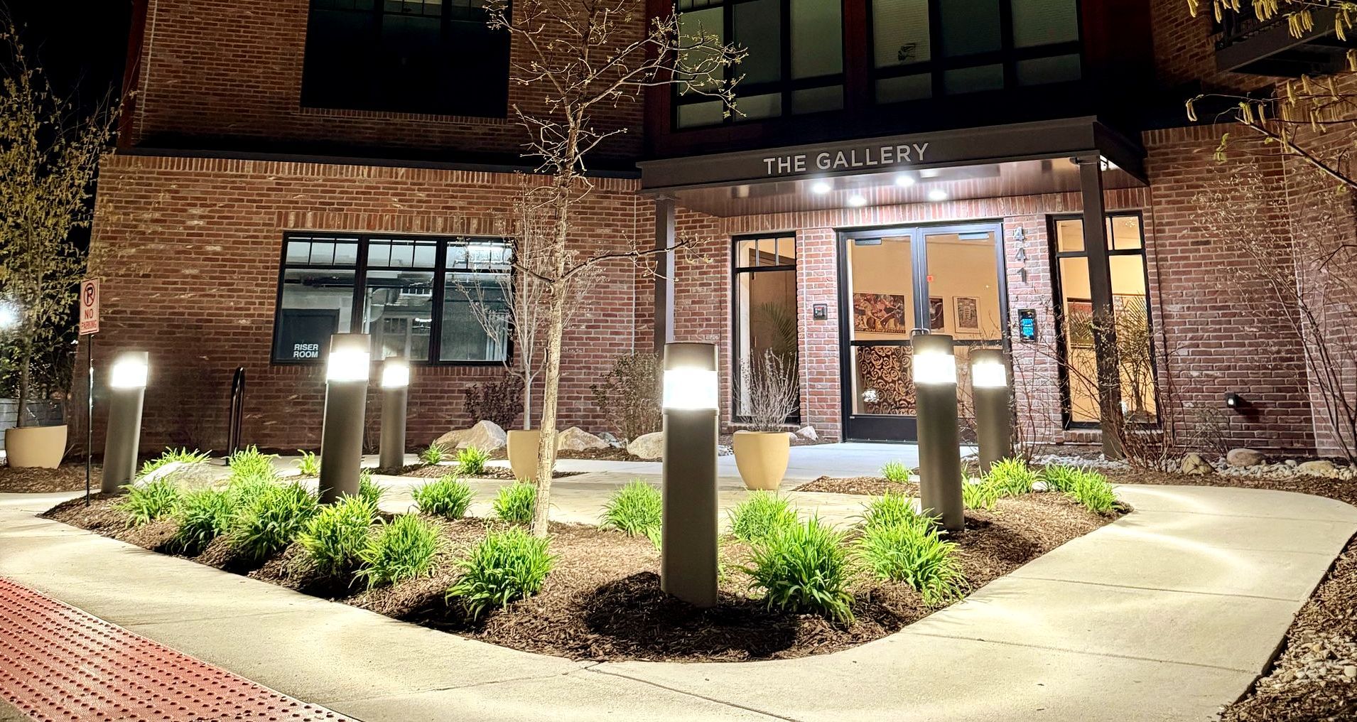 A brick building with a walkway leading to it at night