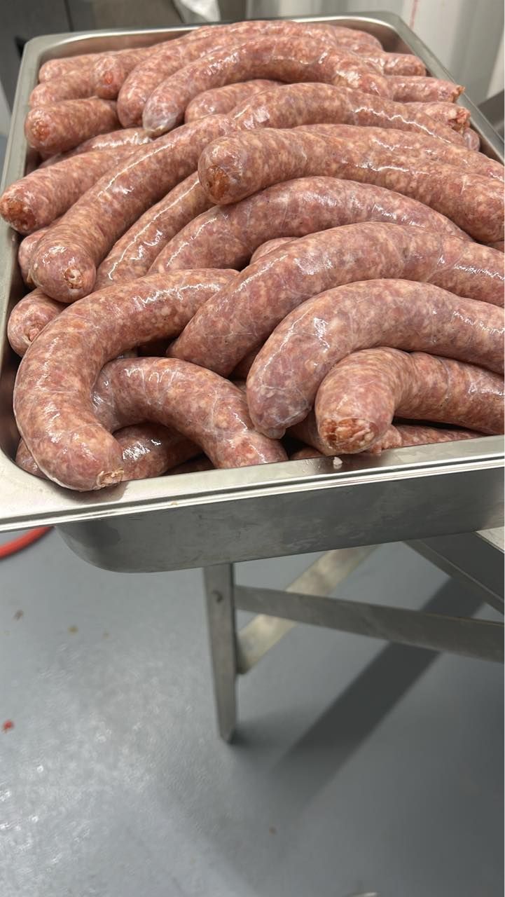 Raw sausages in a stainless steel tray, ready for cooking.