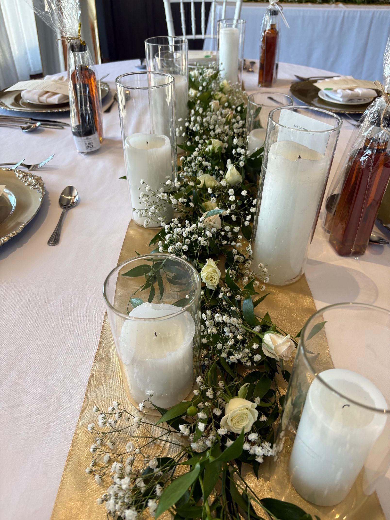 Bougies blanches et centre de table végétal sur une table à manger décorée