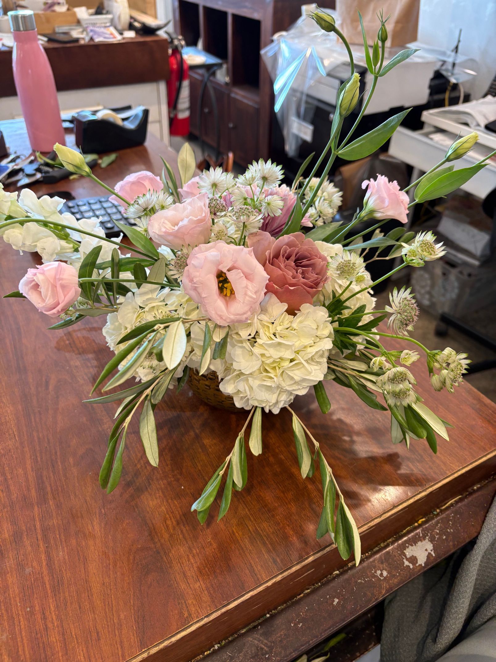 Composition florale rose et blanche dans un vase sur une table en bois