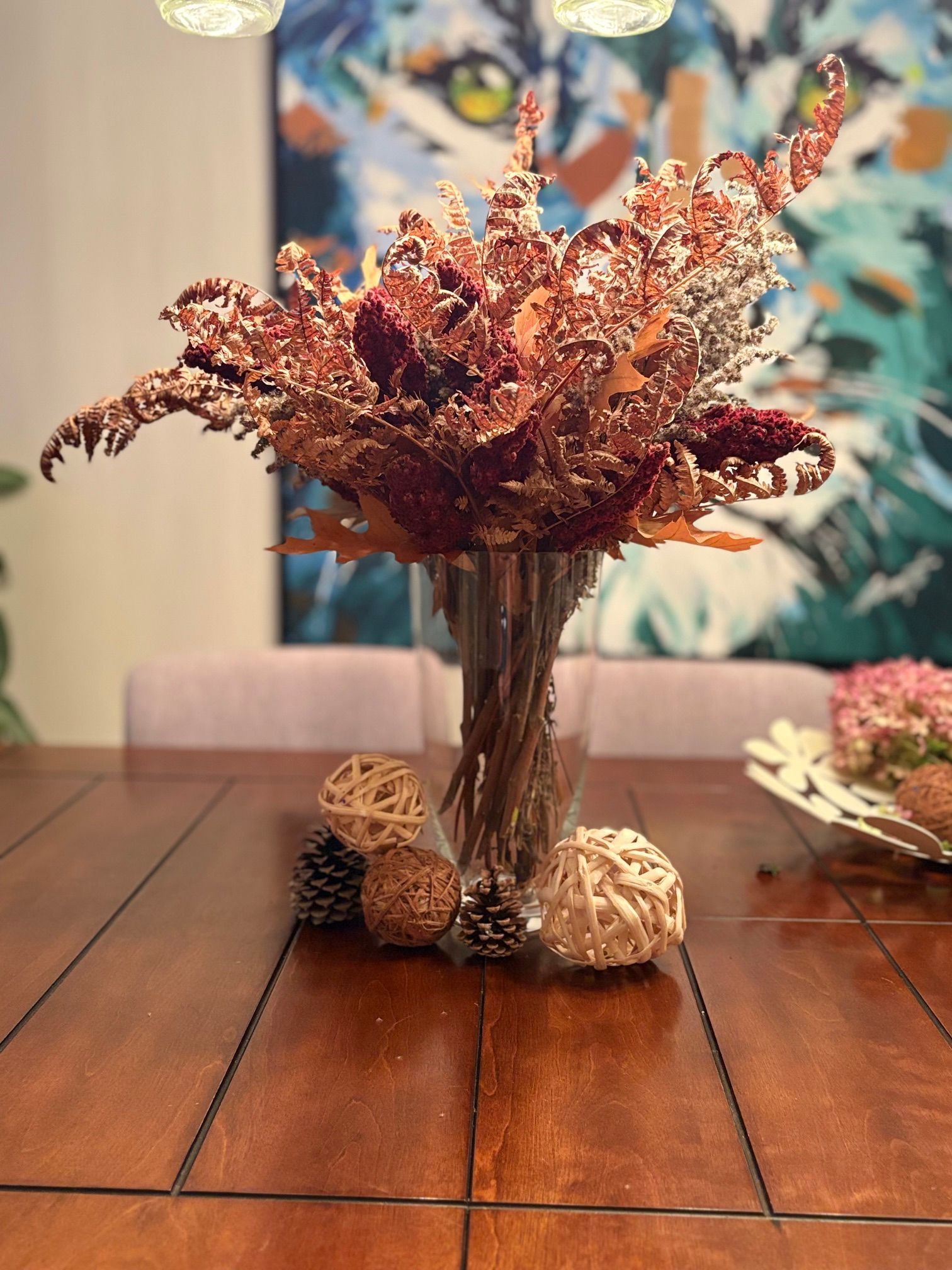 Composition florale séchée d'automne dans un vase en verre sur une table à manger en bois