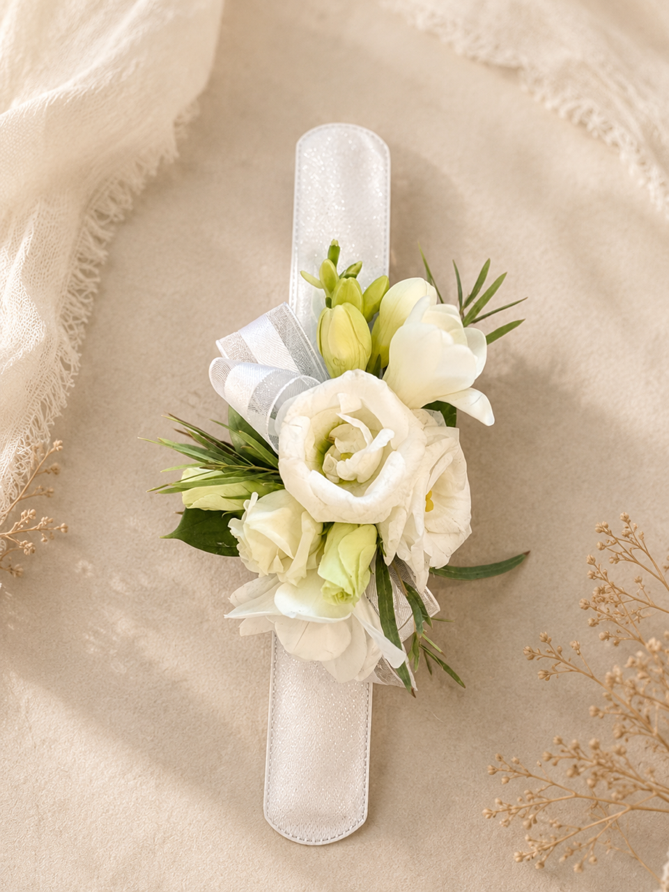 Bracelet de fleurs blanches avec ruban sur fond de tissu beige