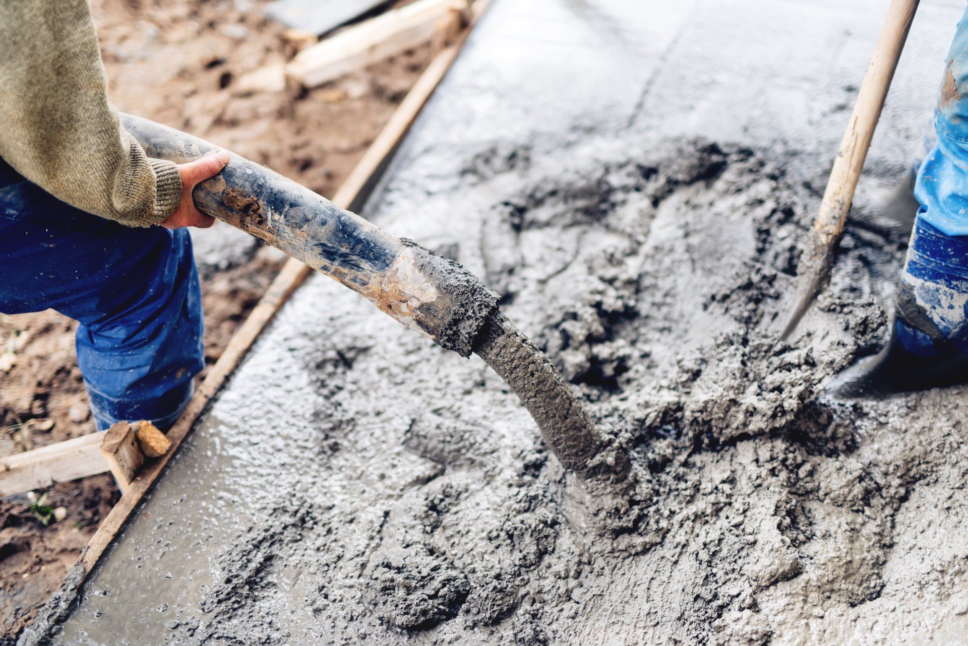 industrial construction workers using automatic pump tube for pouring cement on reinforcement bars