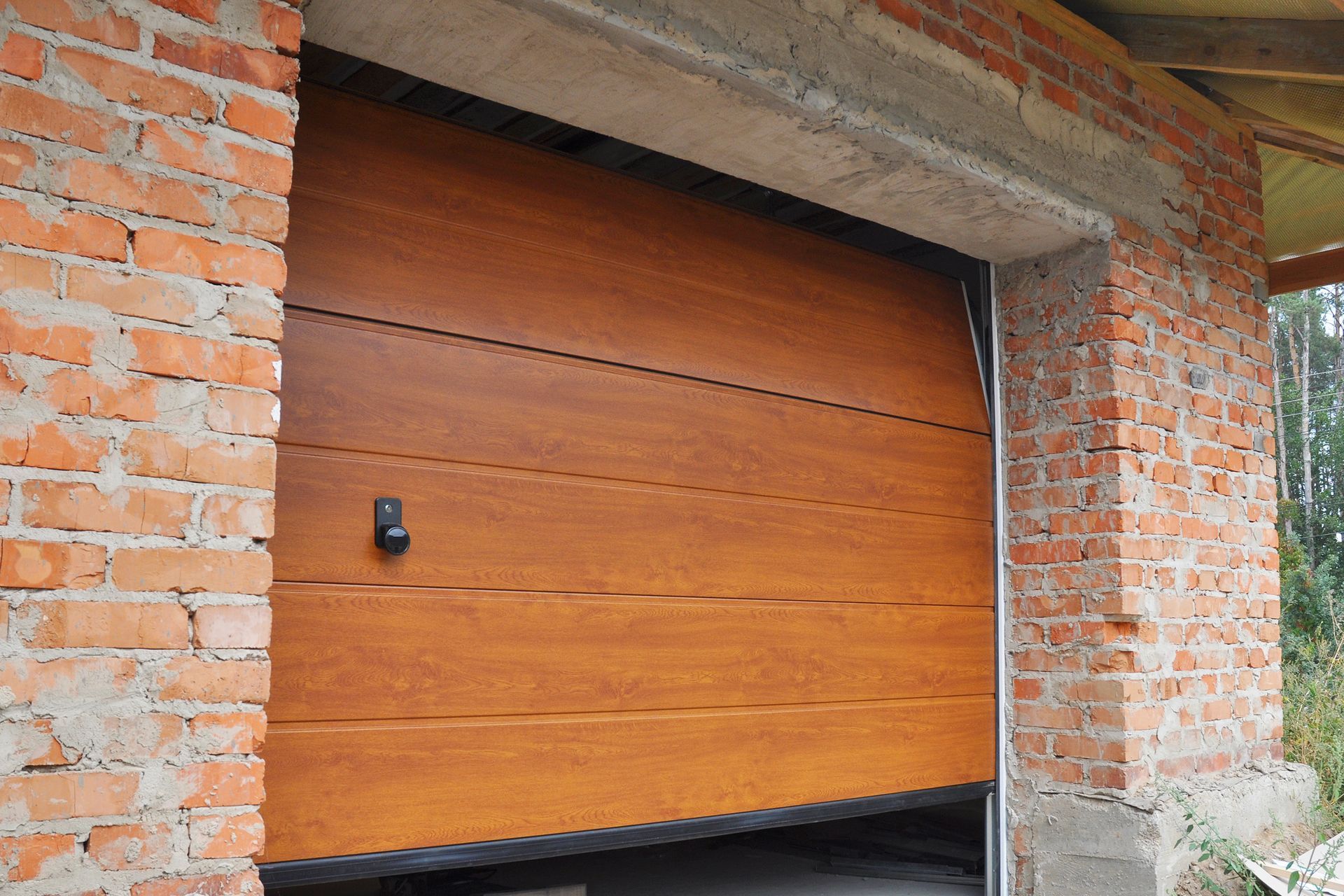 Wooden Garage Door in A Brick Building — Denison, TX — North Central Door and Gate
