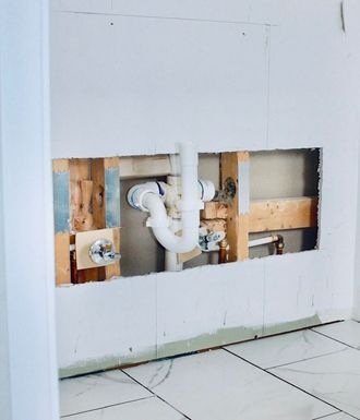 A bathroom sink is being installed in a hole in the wall