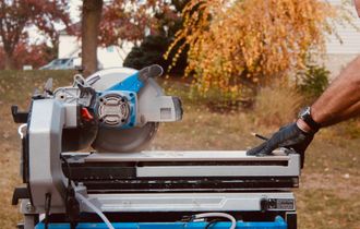 A man is cutting a tile with a circular saw.