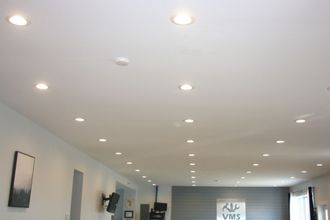 A living room with a lot of lights on the ceiling.