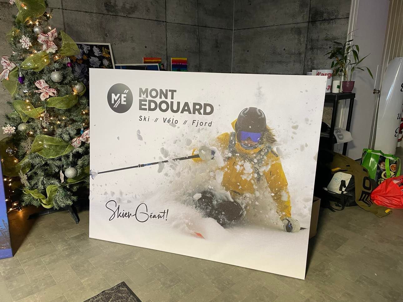 Une peinture représentant une personne skiant devant un sapin de Noël.