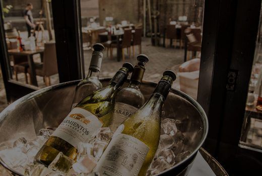 Drie wijnflessen in een ijsemmer op een restauranttafel bij de Moriaan in Roosendaal