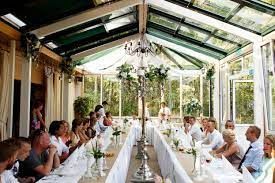 Een lange feesttafel gedekt voor een bruiloftsreceptie in de tuinkamer van Natuurlijke Kloof - Bergen op Zoom. 