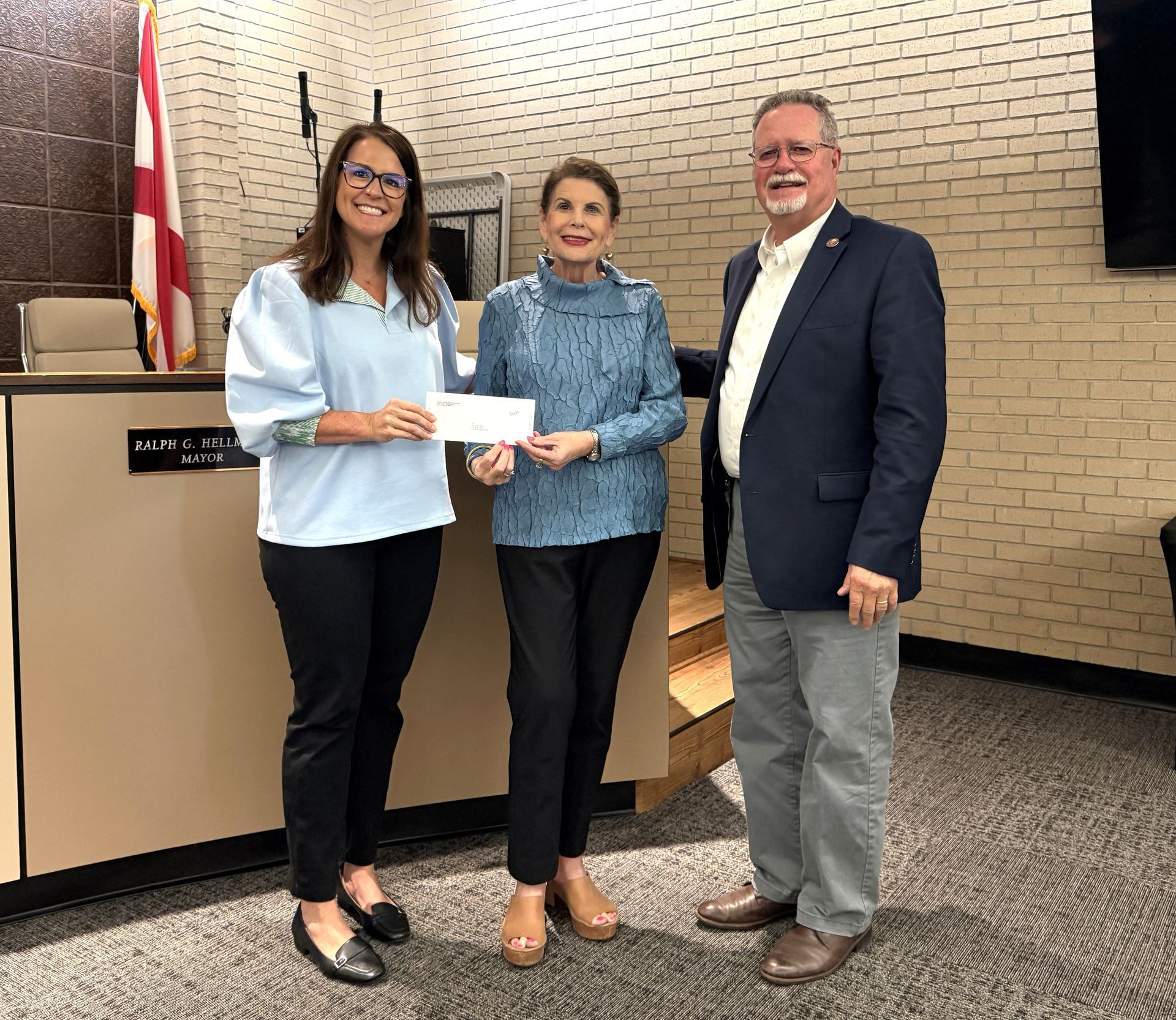 State Rep. Donna Givens, center, presents a check for library funding to Mayor Ralph Hellmich and Foley Library Director Kate Norris. The new facility is scheduled to open later this year.