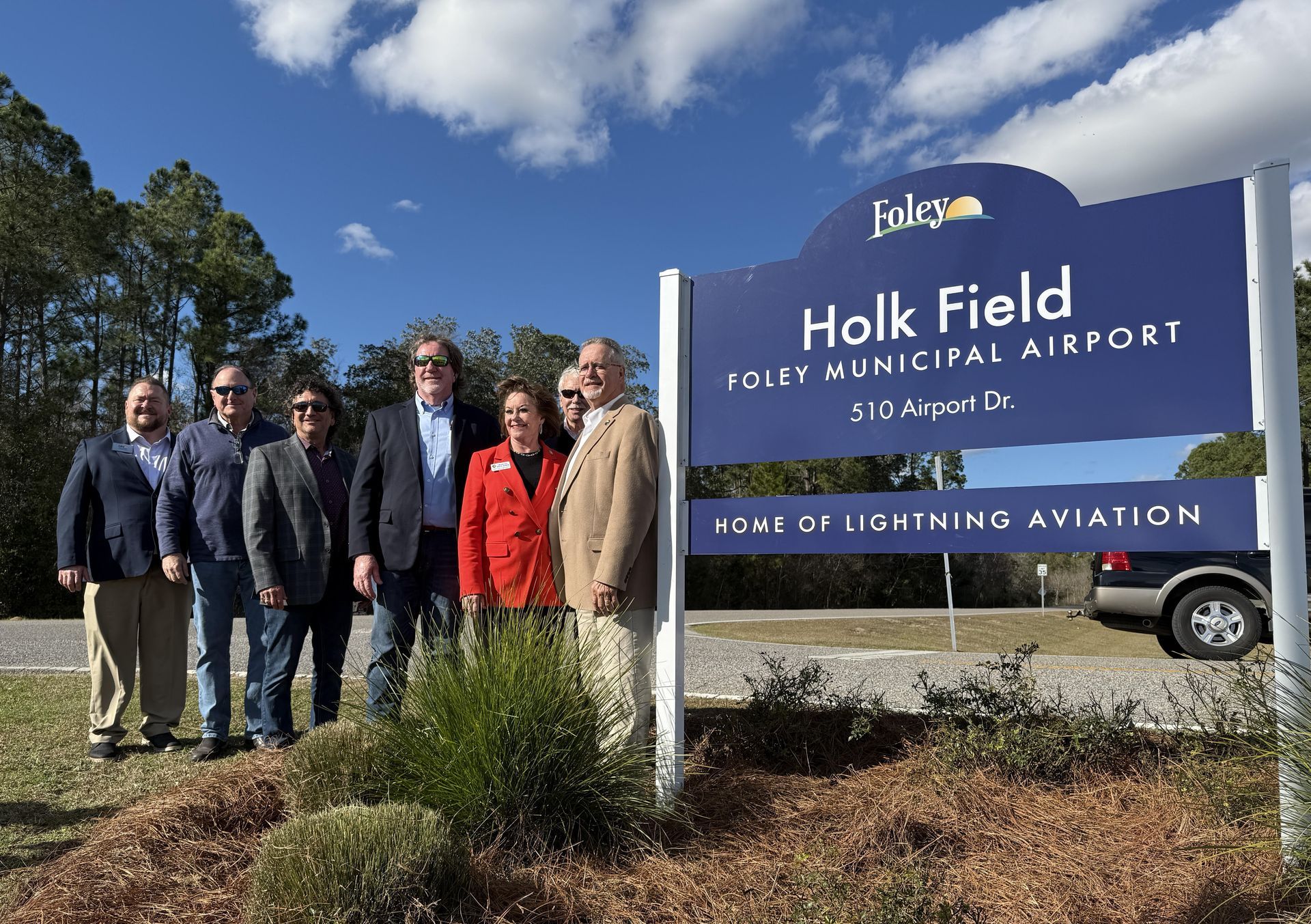 During the dedication of the naming of the Foley airport for former Mayor Arthur
Holk, Mayor Ralph Hellmich, Foley City Council members and two of Holk’s children, State Rep.
Frances Holk-Jones stand next to the new Holk Field at Foley Municipal Airport sign after it is
unveiled.