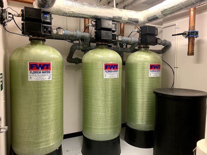 Three green tanks are sitting next to each other in a room.