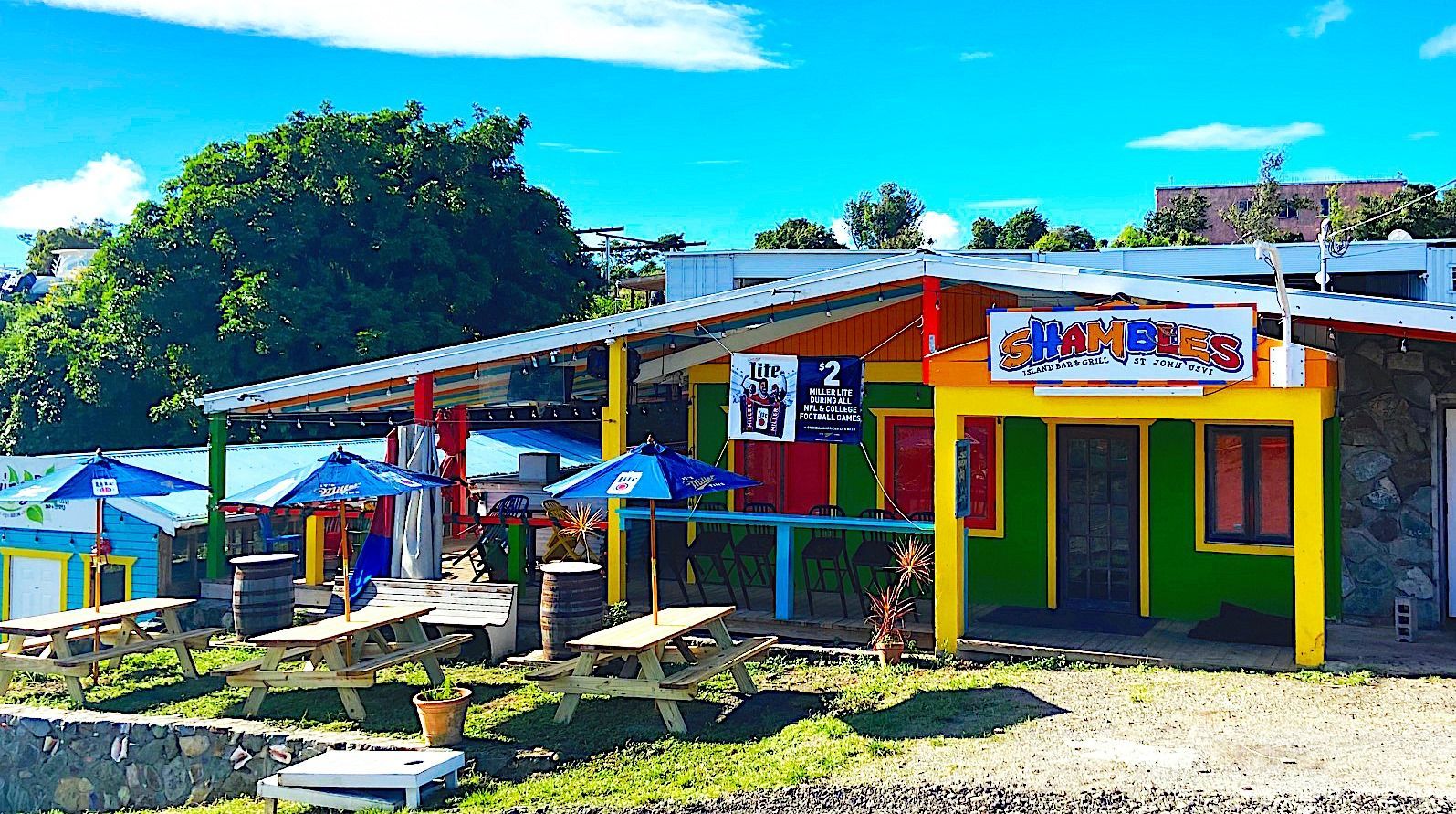 A colorful building with tables and umbrellas in front of it
