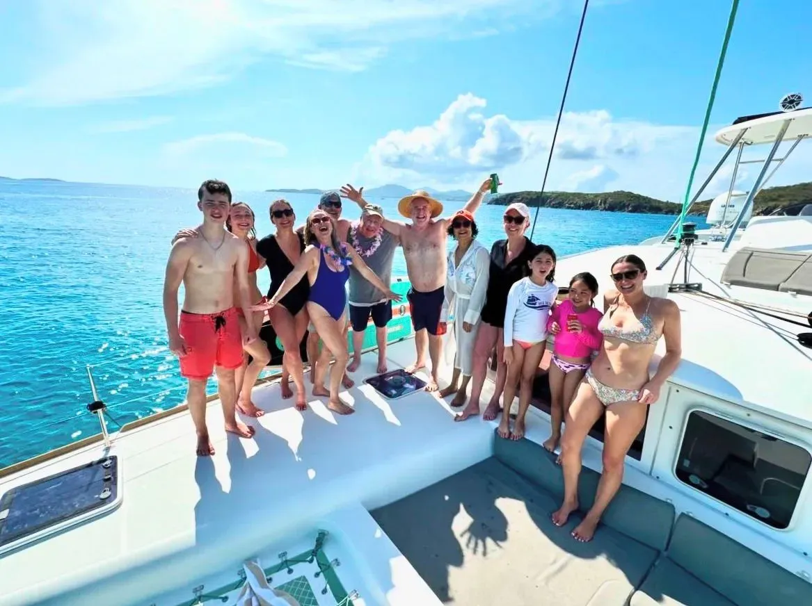 A group of people are posing for a picture on the deck of a boat.
