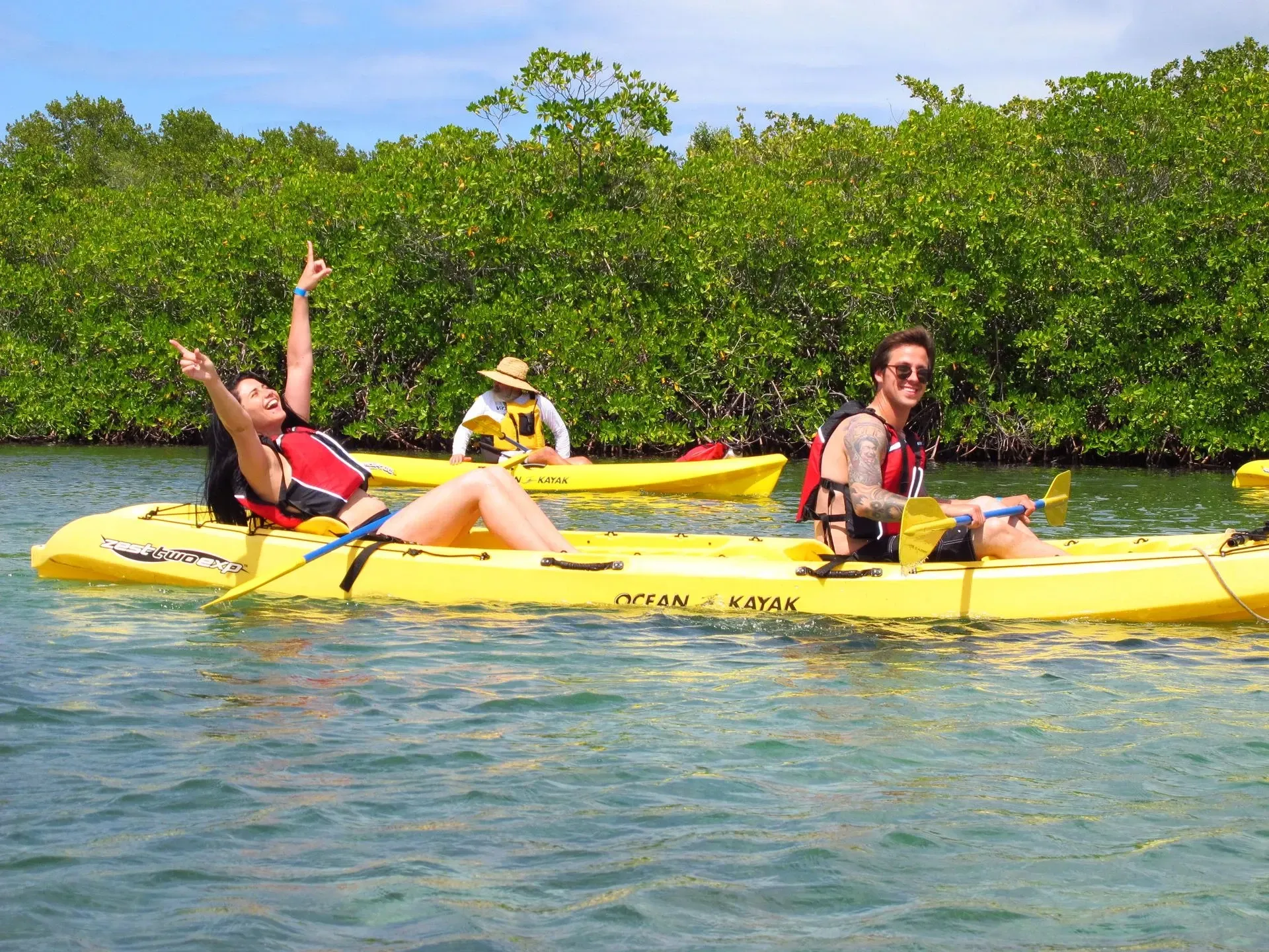 A group of people are in yellow kayaks in the water.