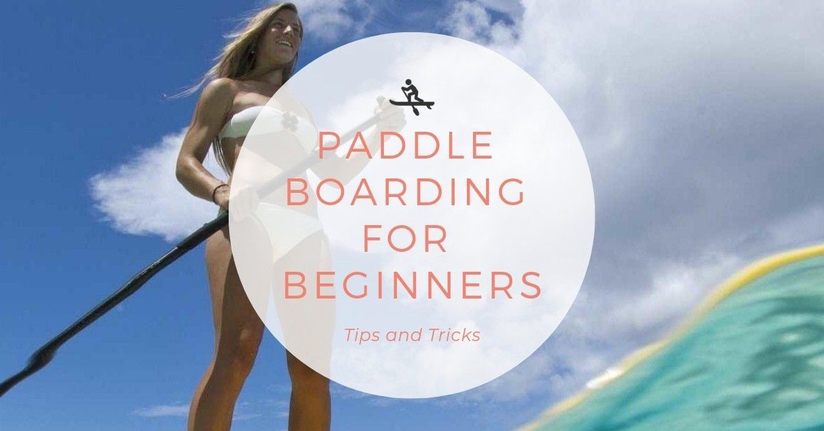 A woman is standing on a paddle board in the water.