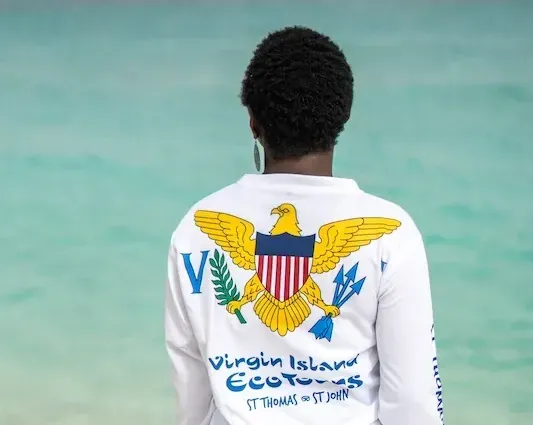 A person wearing a white shirt with an eagle on it