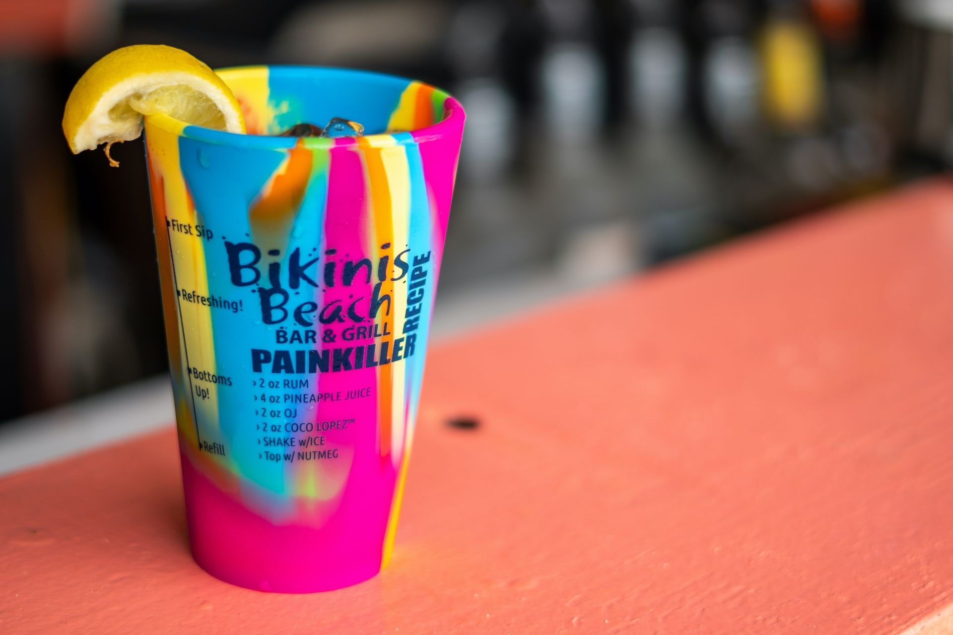 A bikinis beach shot glass with a lemon slice in it