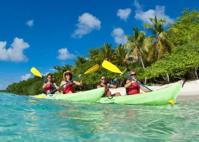 A group of people are paddling kayaks in the ocean.
