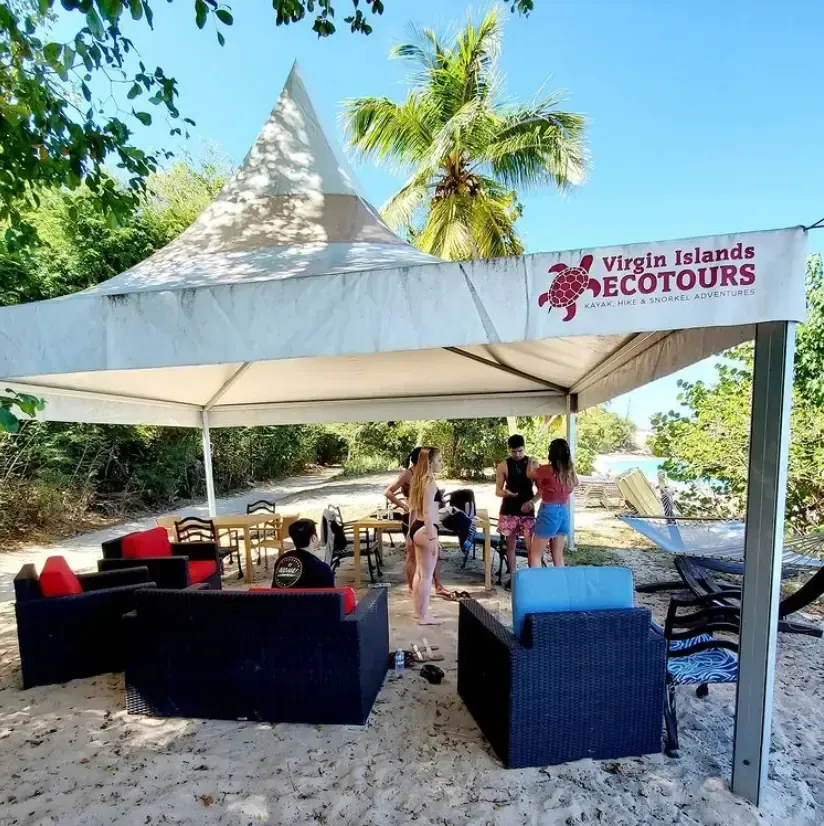 A group of people standing under a tent that says virgin islands ecotours