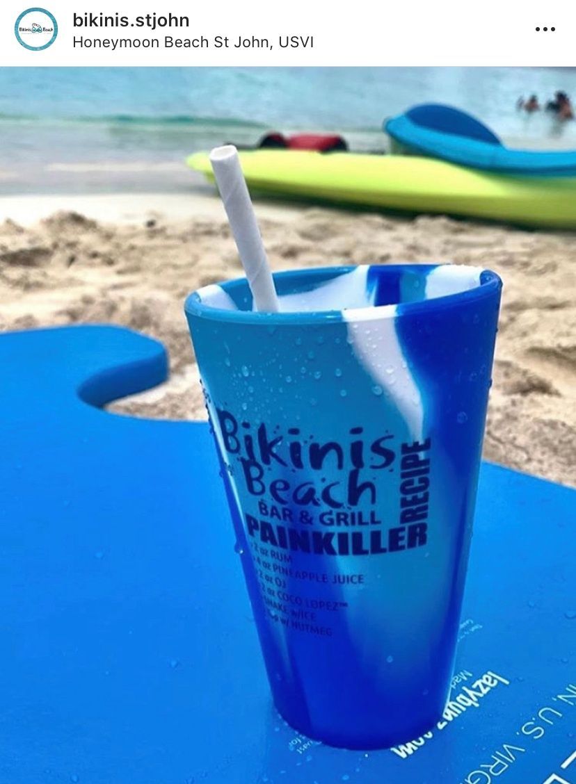 A blue cup with a straw in it that says bikinis beach