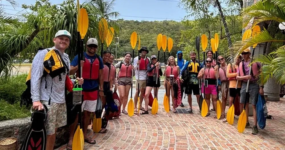 People holding kayak paddles in front of Virgin Islands Ecotours, Mongoose Junction shop on St. John USVI