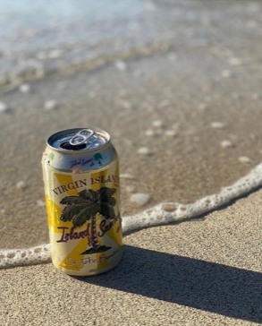 A can of virgin island beer is sitting on the beach.