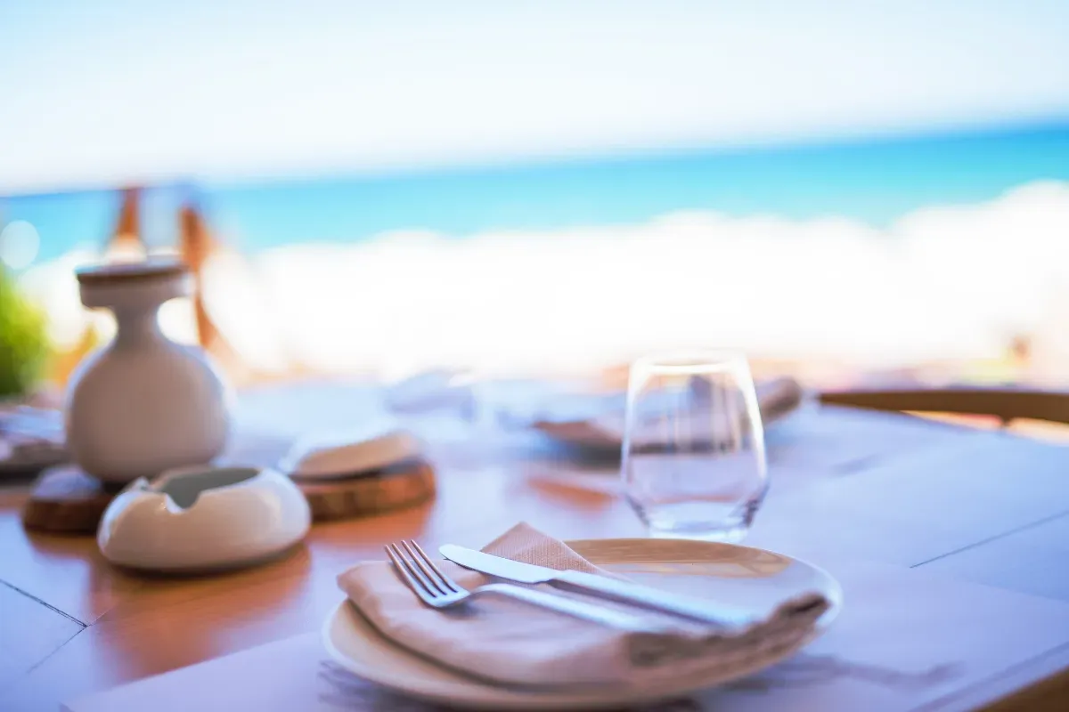 A table set for a meal with a view of the ocean.