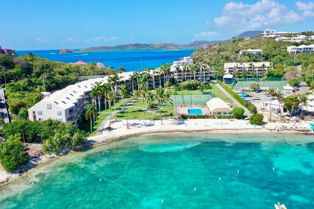 An aerial view of a resort on a tropical island surrounded by water.