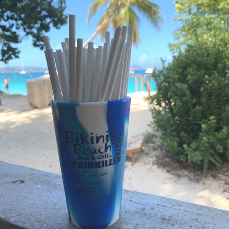 A cup with straws in it that says bikini beach painkiller