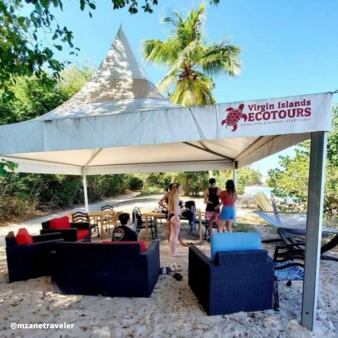 A group of people standing under a tent that says virgin islands ecotours