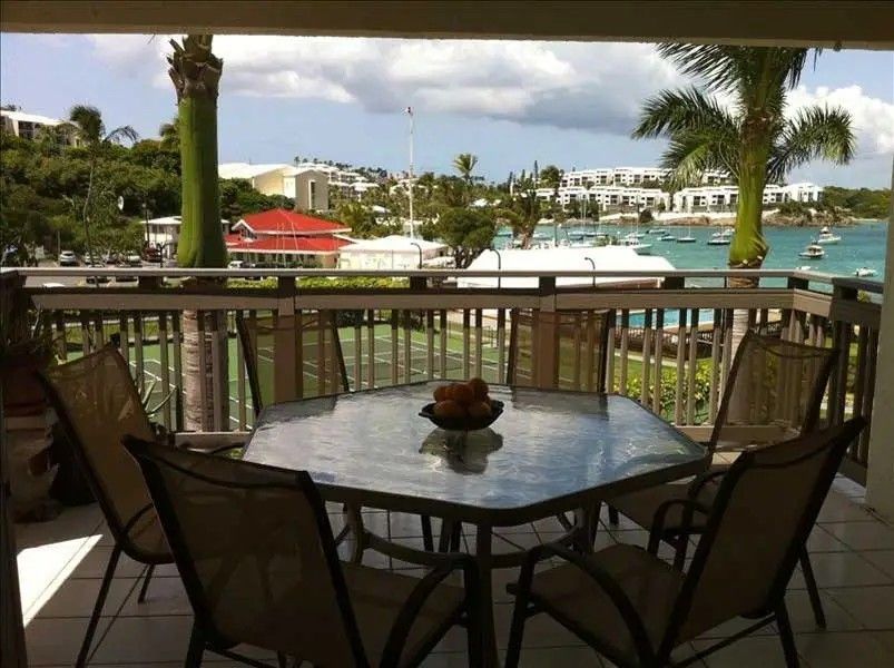 A table and chairs on a balcony overlooking the ocean