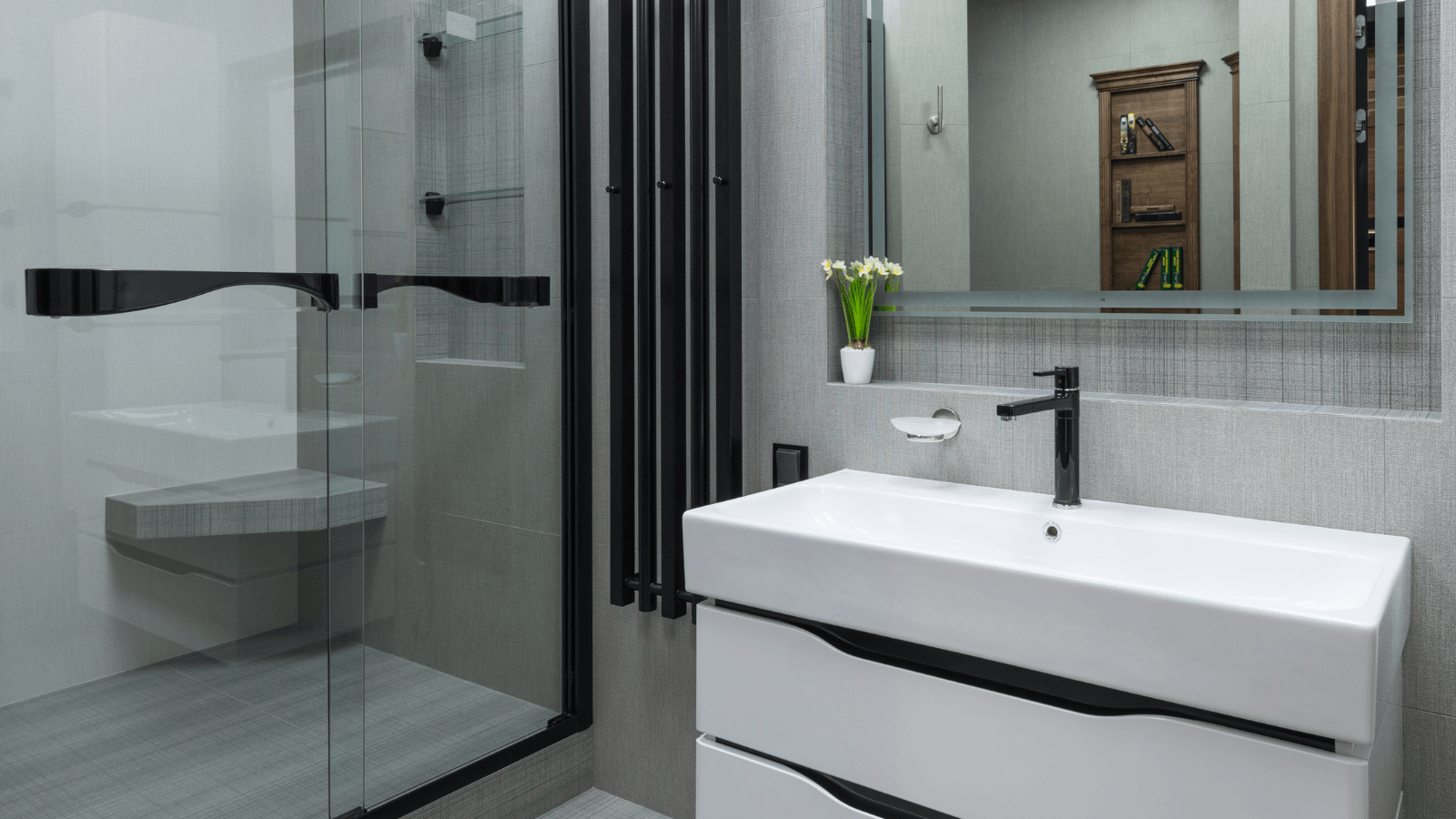 A bathroom with a sink , mirror and walk in shower.