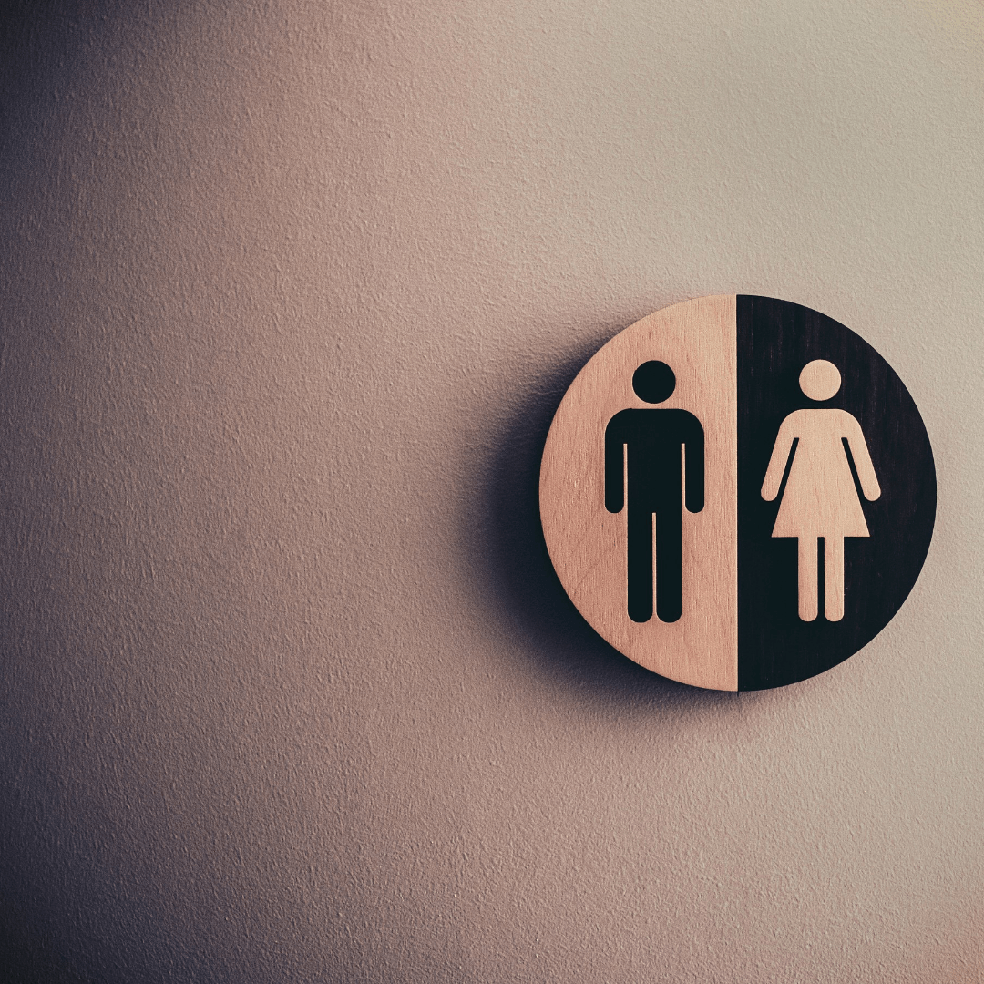A wooden sign with a man and a woman on it