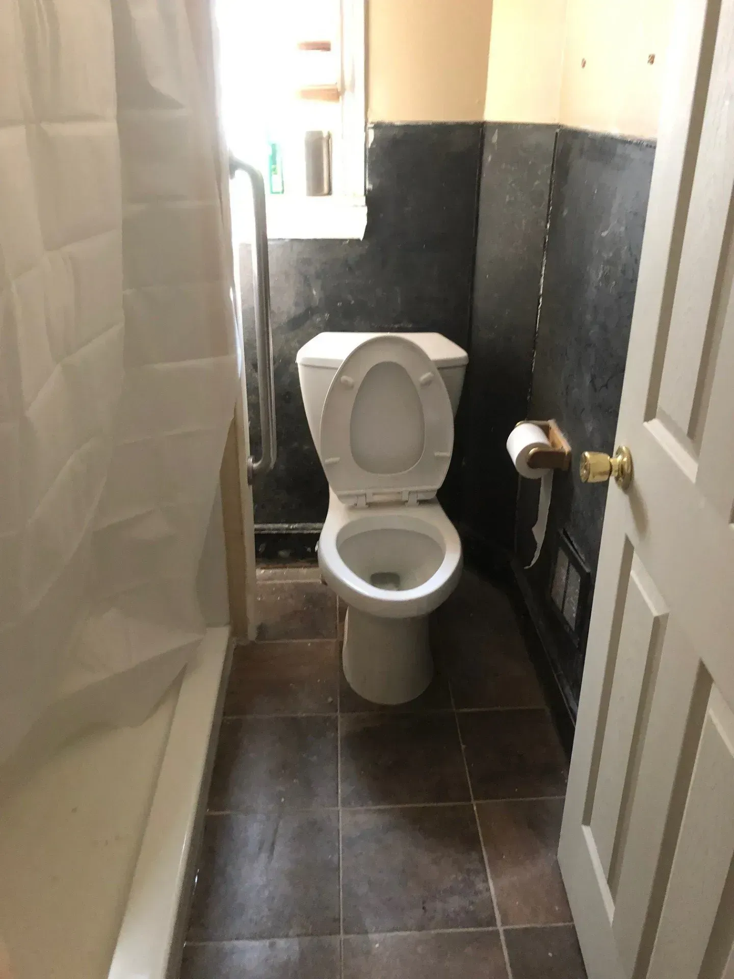 A toilet is sitting in a bathroom next to a shower.