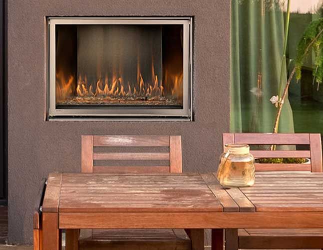 A wooden table and chairs in front of a fireplace.