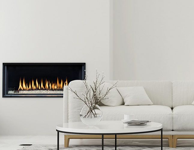 A living room with a couch , coffee table and fireplace.
