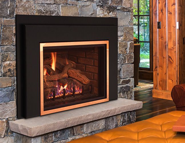 A fireplace in a living room with a copper trim