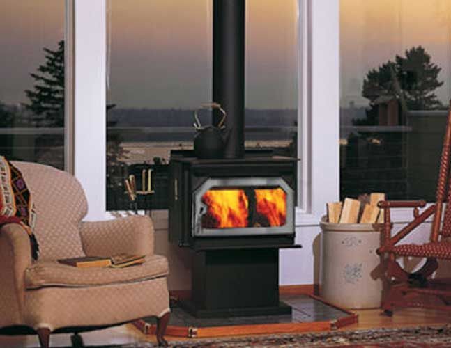 A wood stove in a living room next to a rocking chair