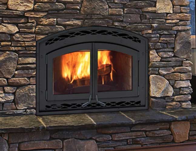 A fireplace in a stone wall with a fire coming out of it