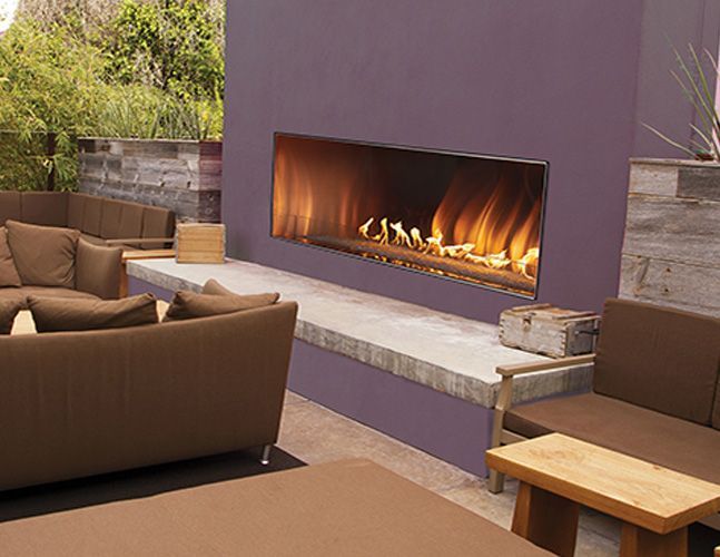 A living room with a purple wall and a fireplace