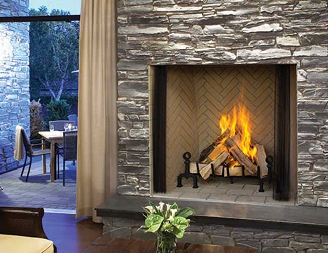 A living room with a fireplace and a patio in the background.
