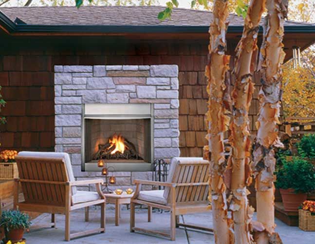 A patio with chairs and a fireplace in the background