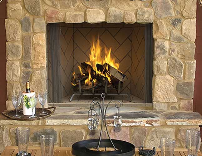 A fireplace with a bottle of wine and glasses in front of it