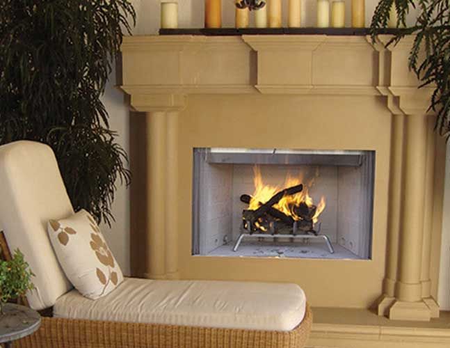A fireplace with a wicker chair in front of it