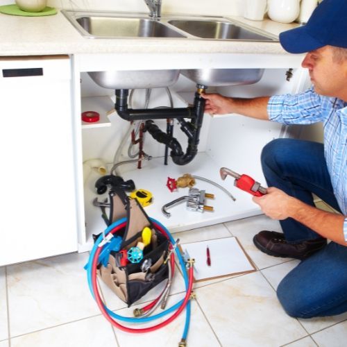 A man is installing a cabinet door in a kitchen.