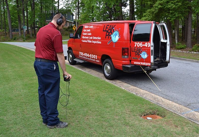 A man is standing in front of a leak detection van